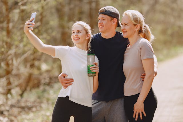 A group of three people take a selfie outside.
