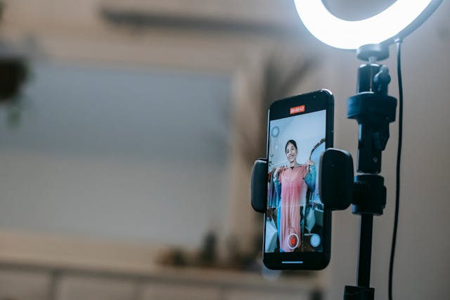 A camera records a woman showing off her dress.
