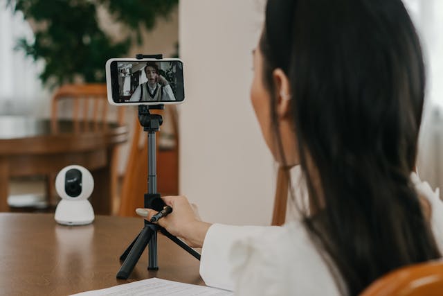 A woman mounts her cell phone on a tripod.