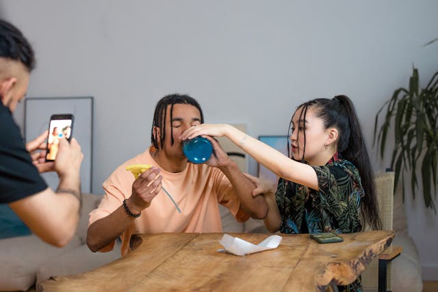 A man records his two friends performing a challenge.
