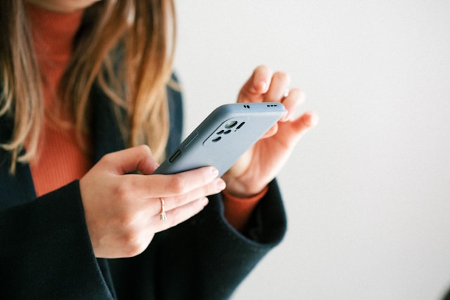 A woman reads TikTok comments on her video on her phone. 
