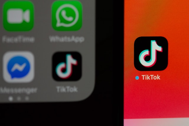 A closeup view of two screens placed side by side with several apps, including TikTok.
