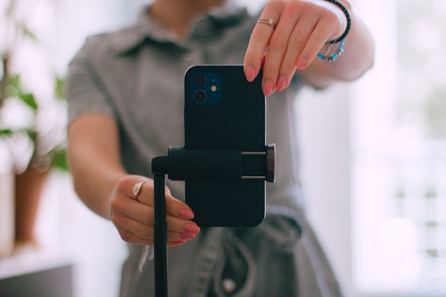 A content creator sets up their phone camera for a TikTok video broadcast. 
