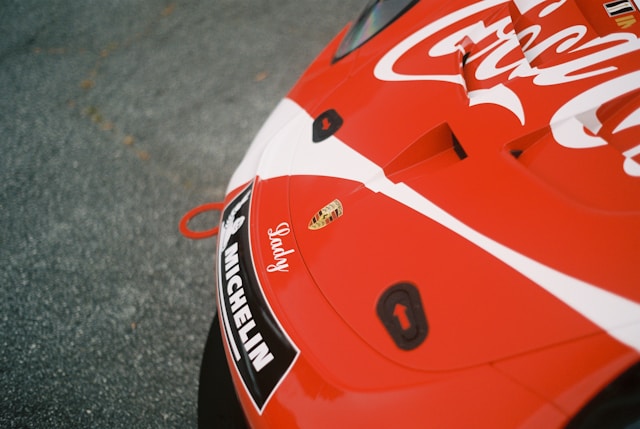 An advertising for Coca-Cola printed on the hood of a sports car. 
