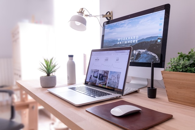 A laptop sits in front of a larger monitor. 
