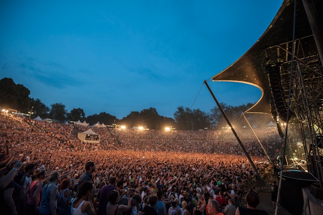 A massive crowd gathers around a stage at an outdoor event.