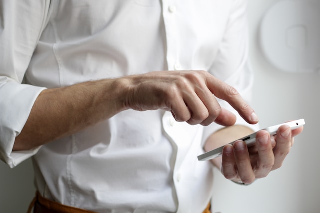 A person’s finger hovers above their phone screen. 
