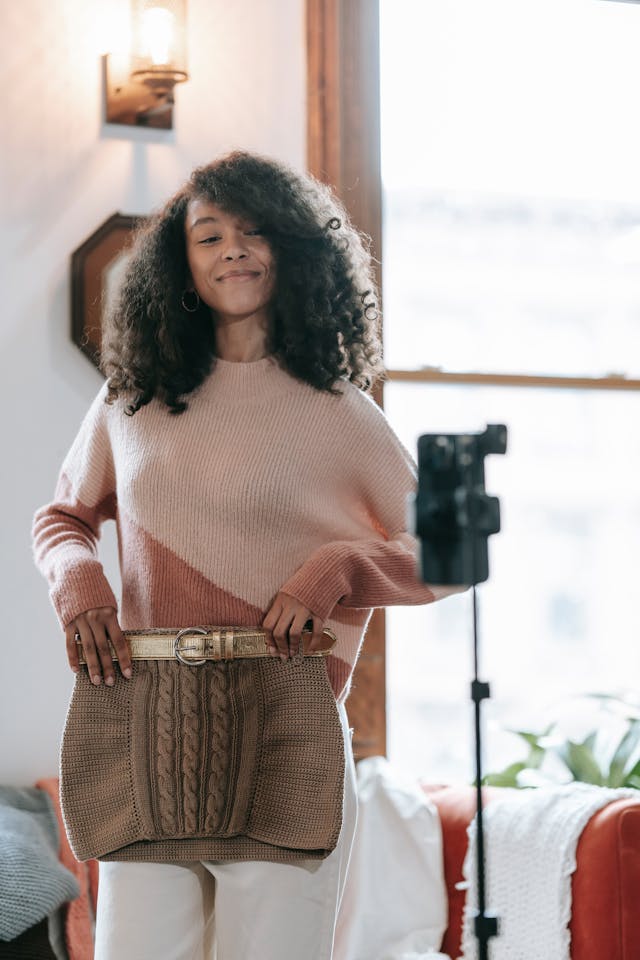 A woman shows off her mini skirt to her camera phone.
