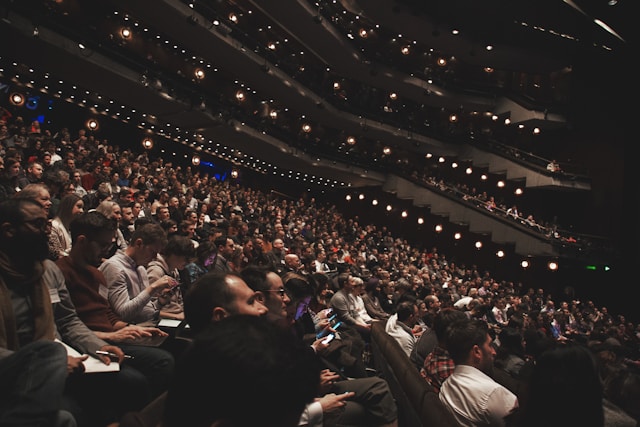 Spectators fill all the seats in a massive indoor stadium. 
