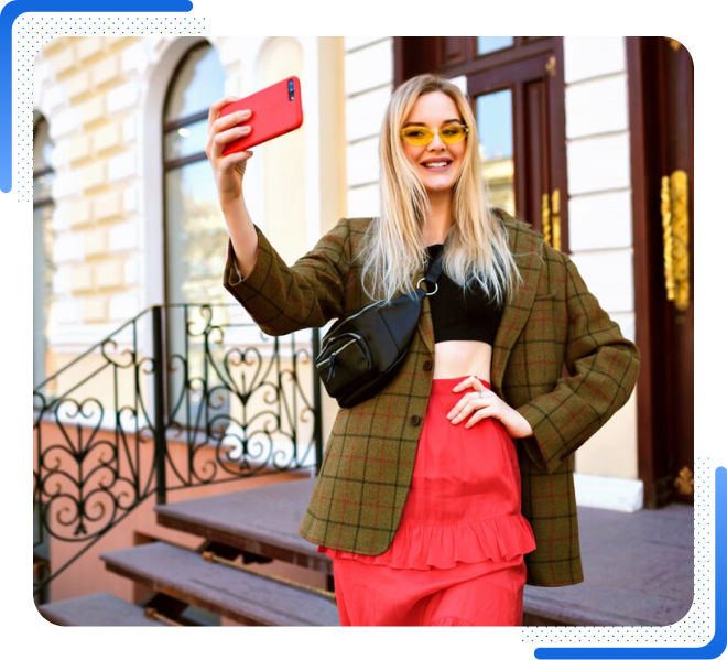 High Social graphic of a smiling female influencer taking a selfie outdoors, wearing sunglasses, a blazer, and a red skirt.